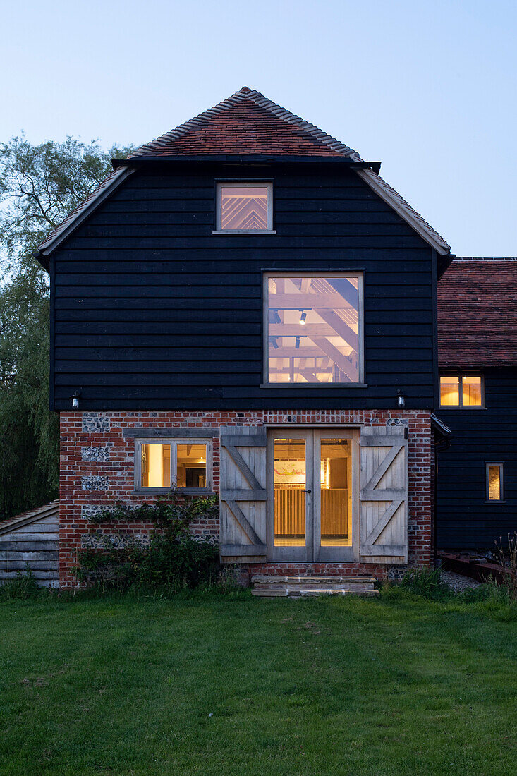 Ehemalige Mühle und Scheune als Wohnhaus bei Abenddämmerung