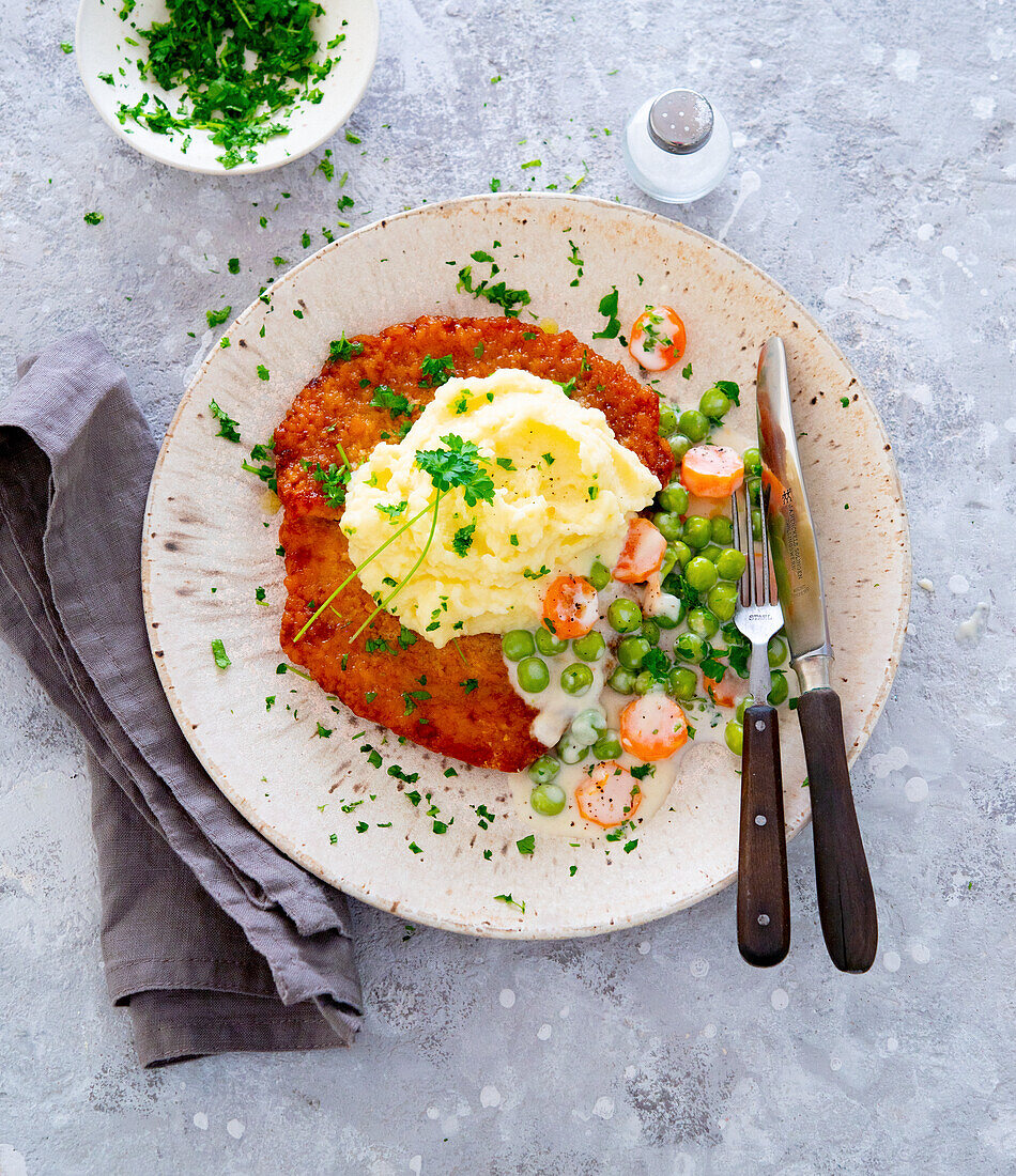 Breaded pork cutlet with mashed potatoes and pea-carrot vegetables