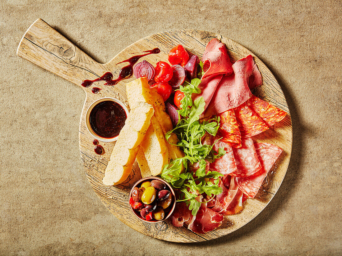 Antipasti-Platte mit Wurst, Oliven und Brotsticks