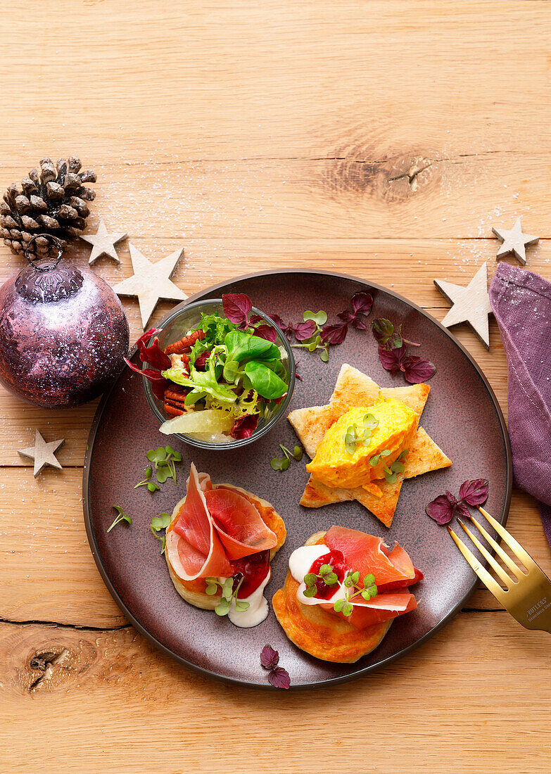 Toast stars with pumpkin cream, blinis with ham, and salad with pecan nuts for Christmas