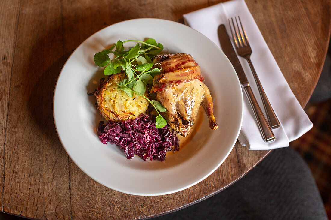 Roasted pheasant with bacon, gravy, potato rösti, red cabbage and pea shoots