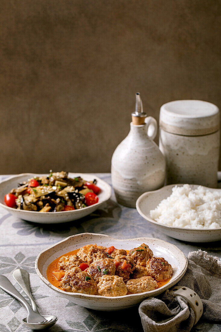 Marinierter Auberginensalat und Fleischbällchen in Tomatensauce, dazu gekochter Reis