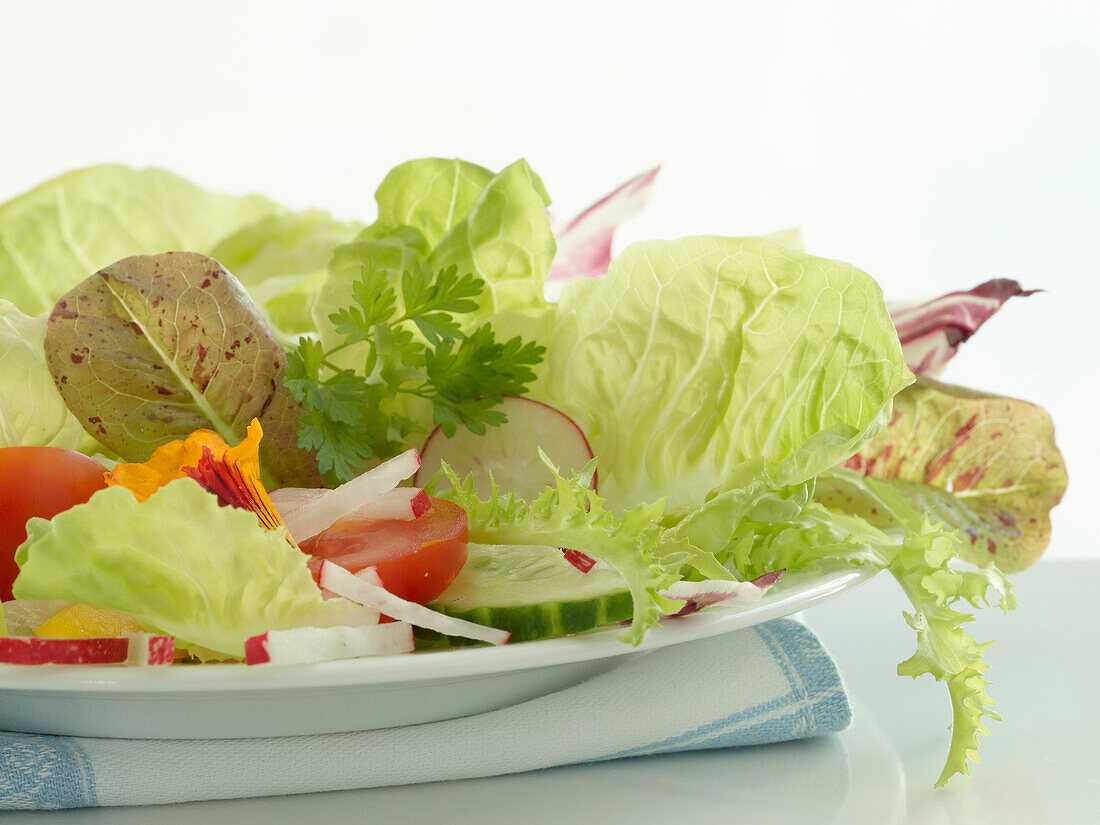 Hellgrüner Salat und verschiedene andere Salatzutaten