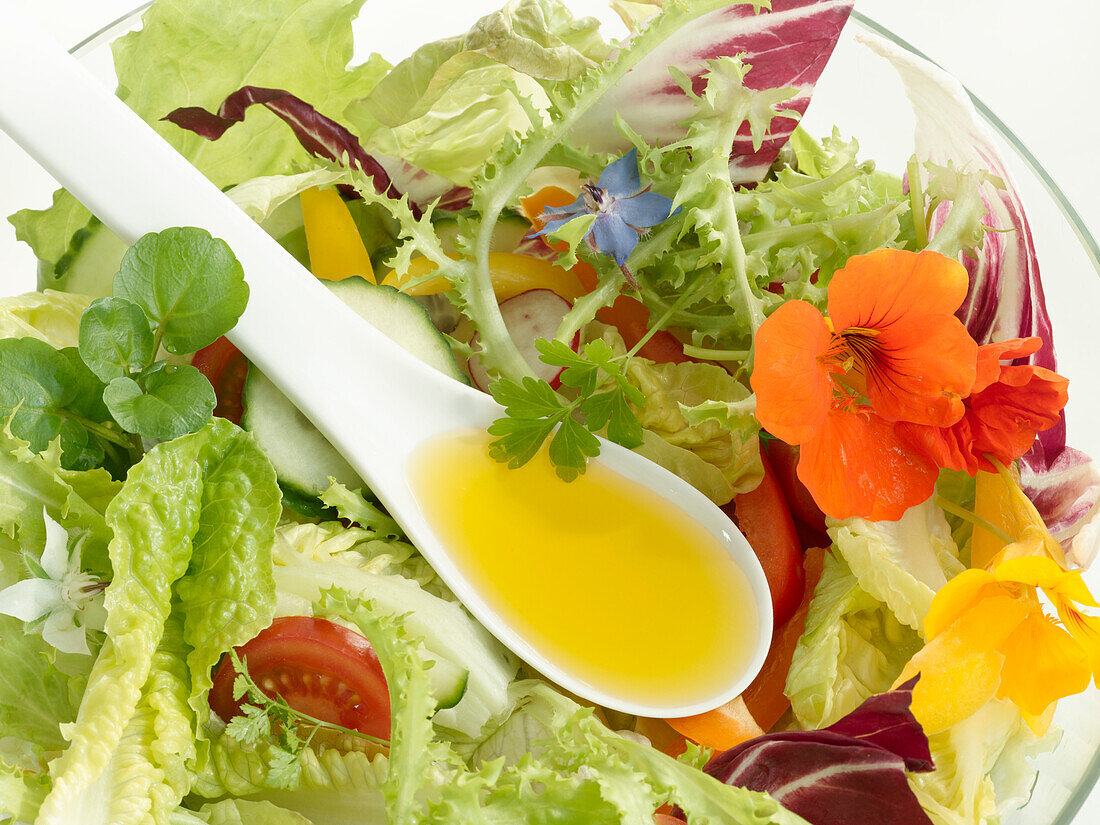 Gemischter Salat mit Kapuzinerkresseblüten und Öl