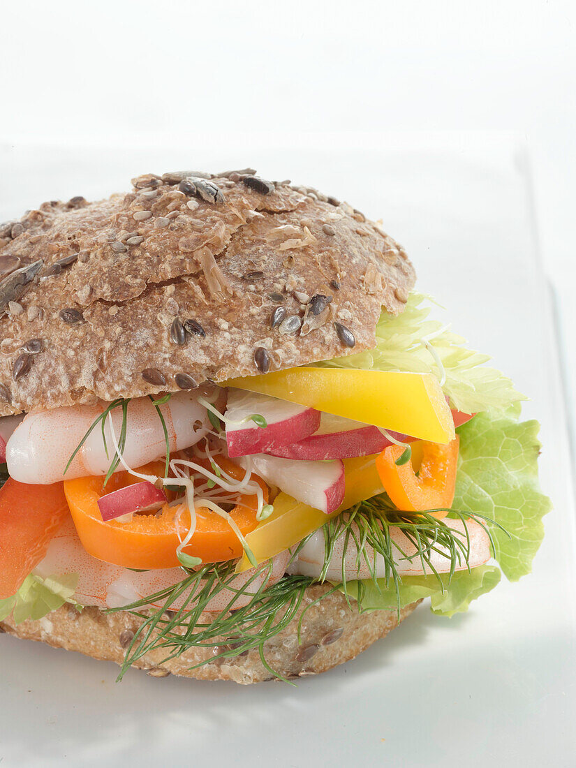 Wholewheat roll with fresh radishes dill, lettuce and sweet peppers, and prawns