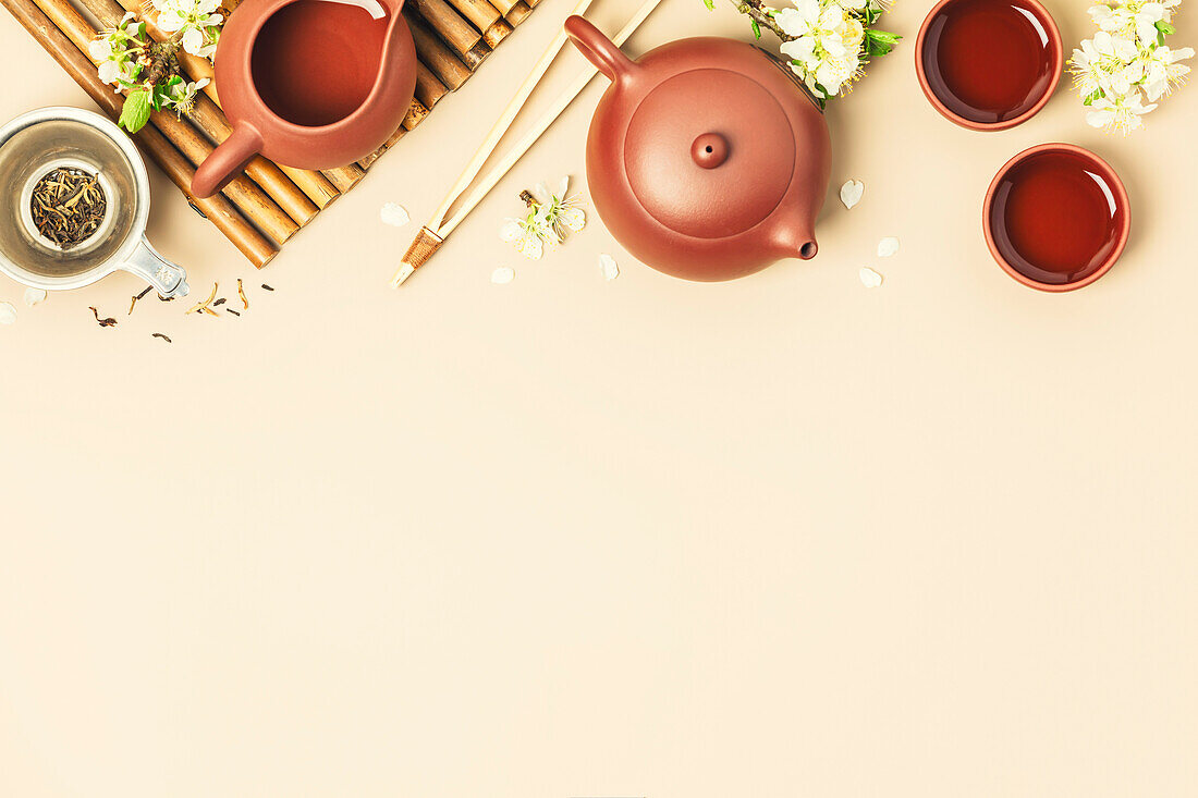 Asiatische Teekanne aus Keramik, Tassen, getrockneter Tee und Frühlingszweige