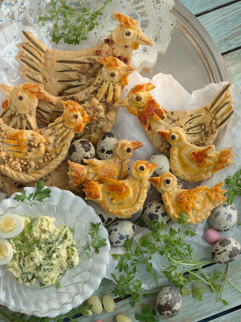 Baked Easter chickens made of shortcrust pastry with herbs, served with quail eggs and chervil butter