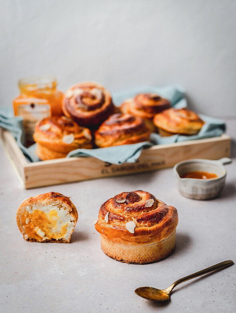 Zimtschnecke mit Mandelblättchen, serviert mit Marmelade und Honig