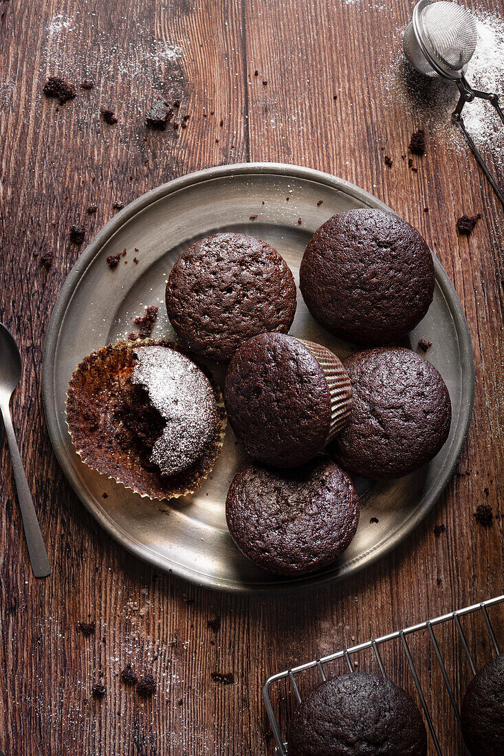 Selbstgemachte Schokoladenmuffins auf Teller und Holztisch