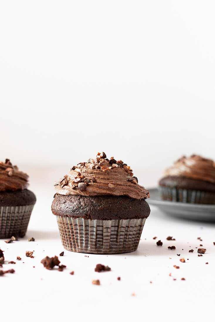 Schokoladen-Cupcakes vor weißem Hintergrund