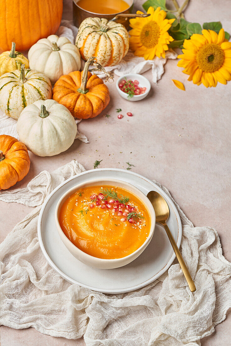 Bowl of tasty pumpkin soup decorated with pomegranate seeds