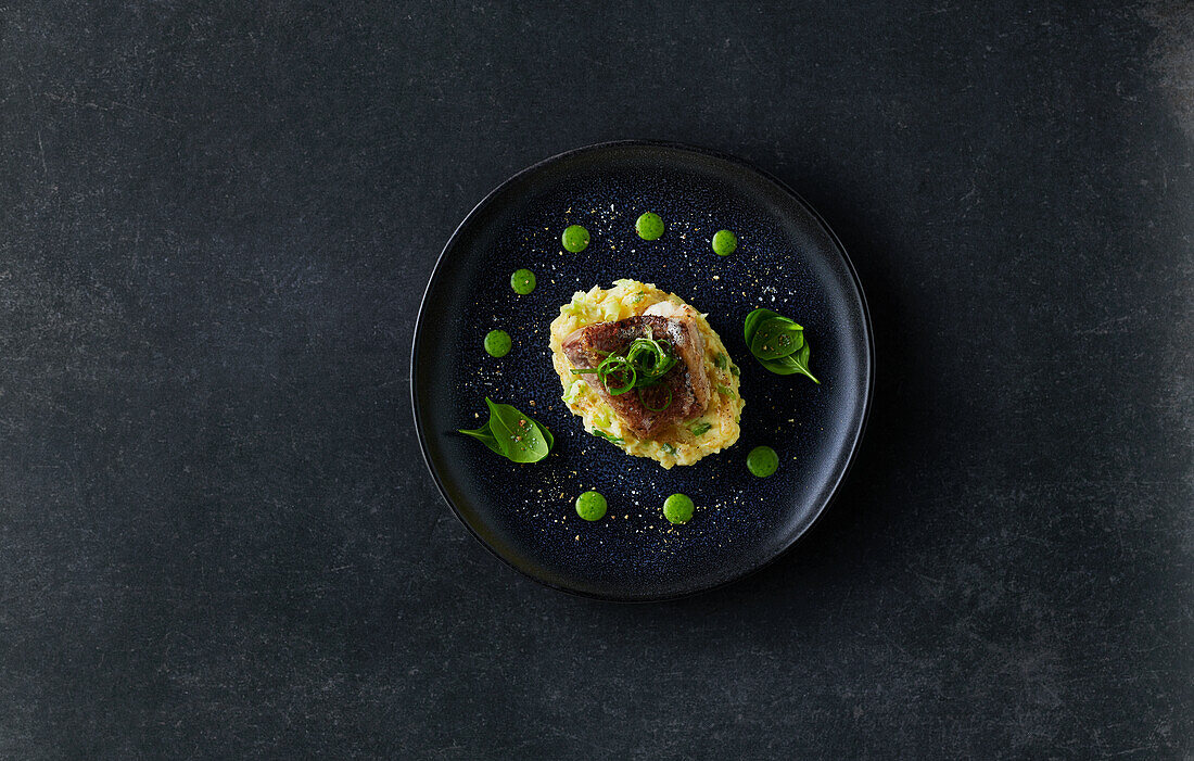 Fried pike-perch with spicy mash on a dark stone background