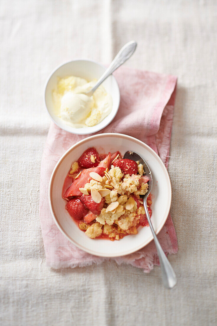 Erdbeer-Rhabarber-Crumble, serviert mit Vanilleeis
