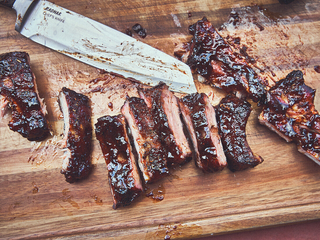 Spareribs from the rotisserie, cut on a wooden board