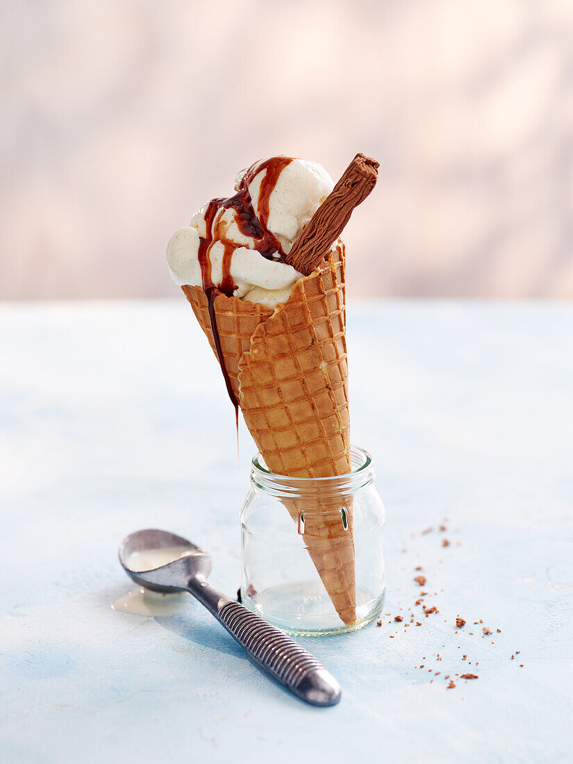 Vanilla ice cream with waffle cone and chocolate sauce
