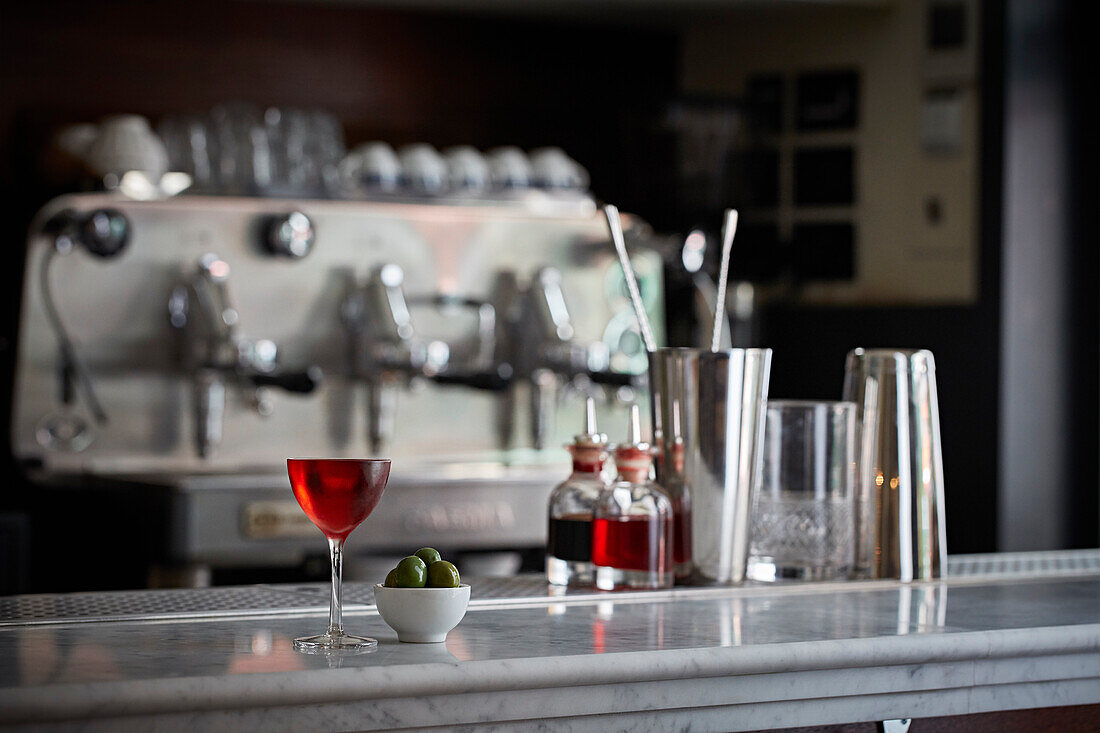 Chilled Negroni in an elegant glass served with olives on a bar