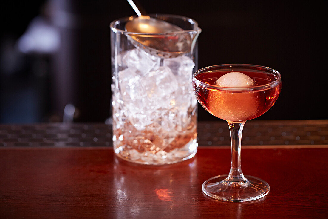 Cocktail mit Litschi auf Bartheke