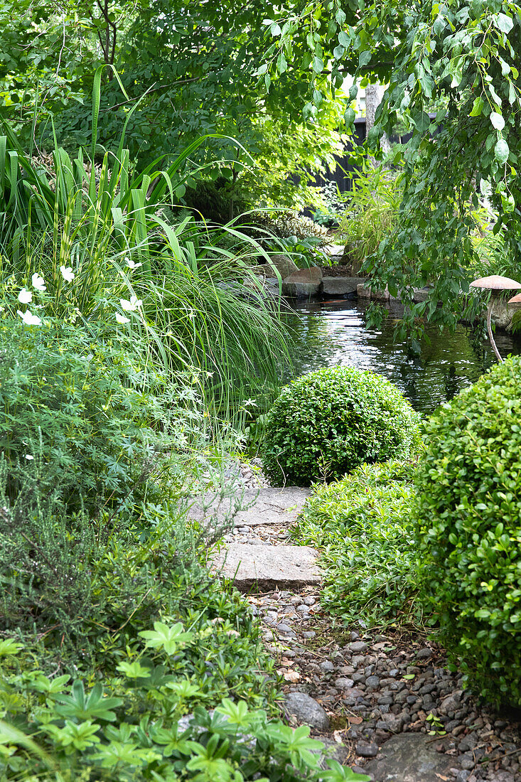 Garden path made of pebbles and pond in the background