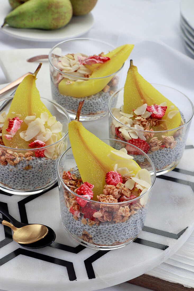 Chiapudding mit Müsli, Beeren und in Kurkuma gekochten Birnen