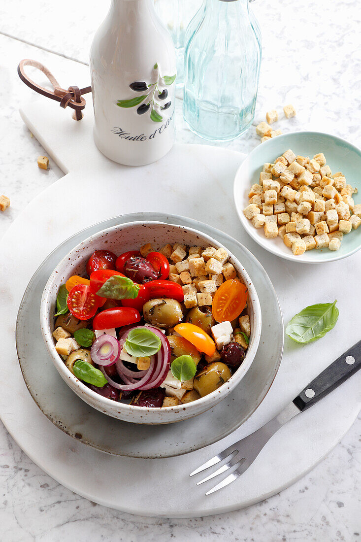 Mediterraner Salat mit Tomaten, Oliven, Schafskäse und Croutons