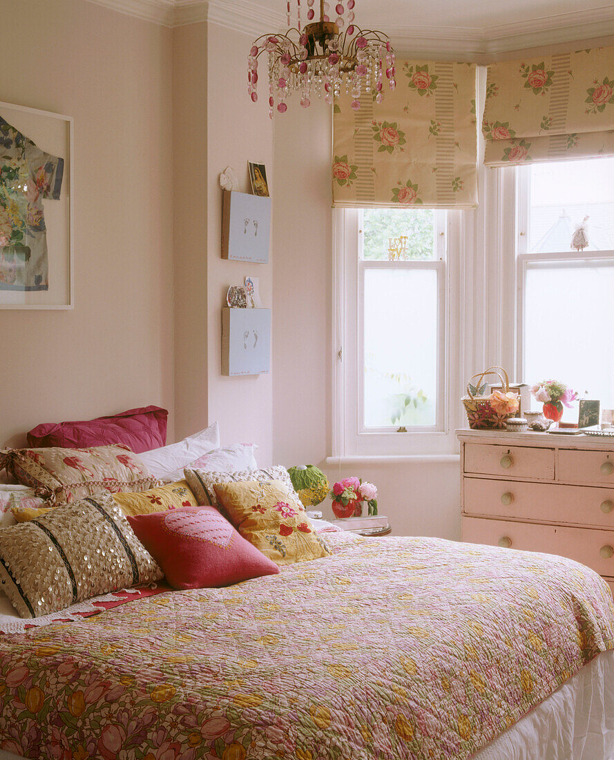 A traditional master bedroom with a bay window double bed embroidered cushions on a bed