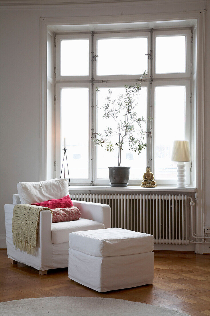 Armchair and footstool at window of 20th century Stockholm apartment