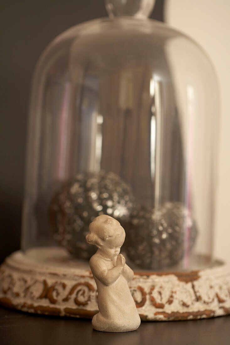 Figurine of child praying and bell jar