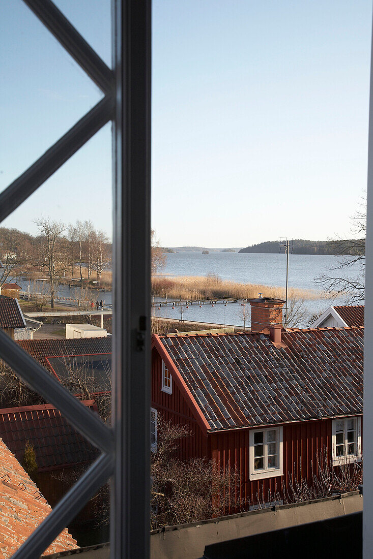 View through open window over lake island rooftops