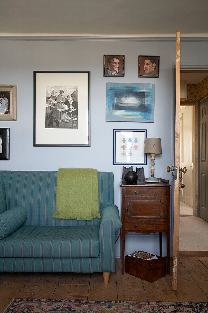 Artwork displayed above striped turquoise sofa in Rye living room, Sussex