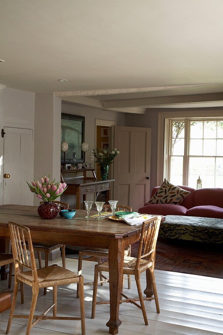 Wooden dining table and chairs with sofa in Rye cottage, Sussex