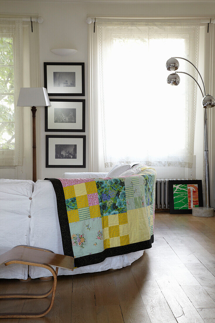 Patchwork blanket on the back of sofa in sunlit room