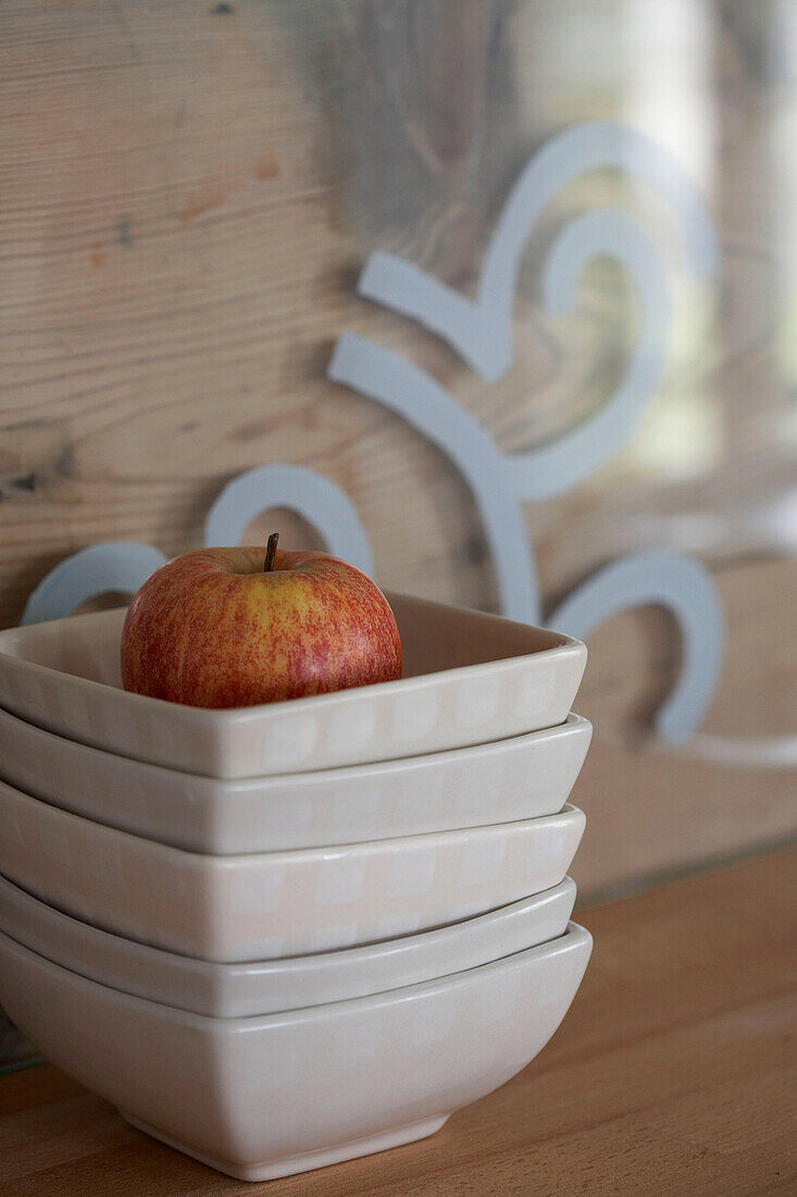 Red apple in stack of bowls