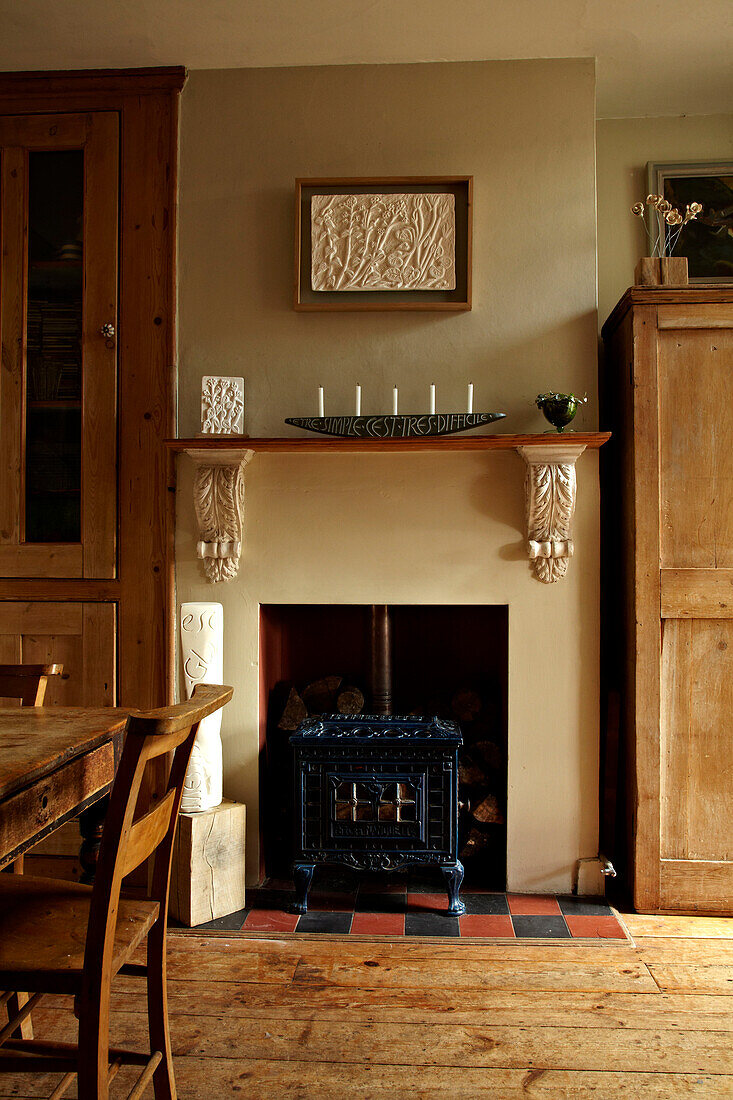 Holzofen in einem eingebauten Kamin im Esszimmer in Brighton, UK