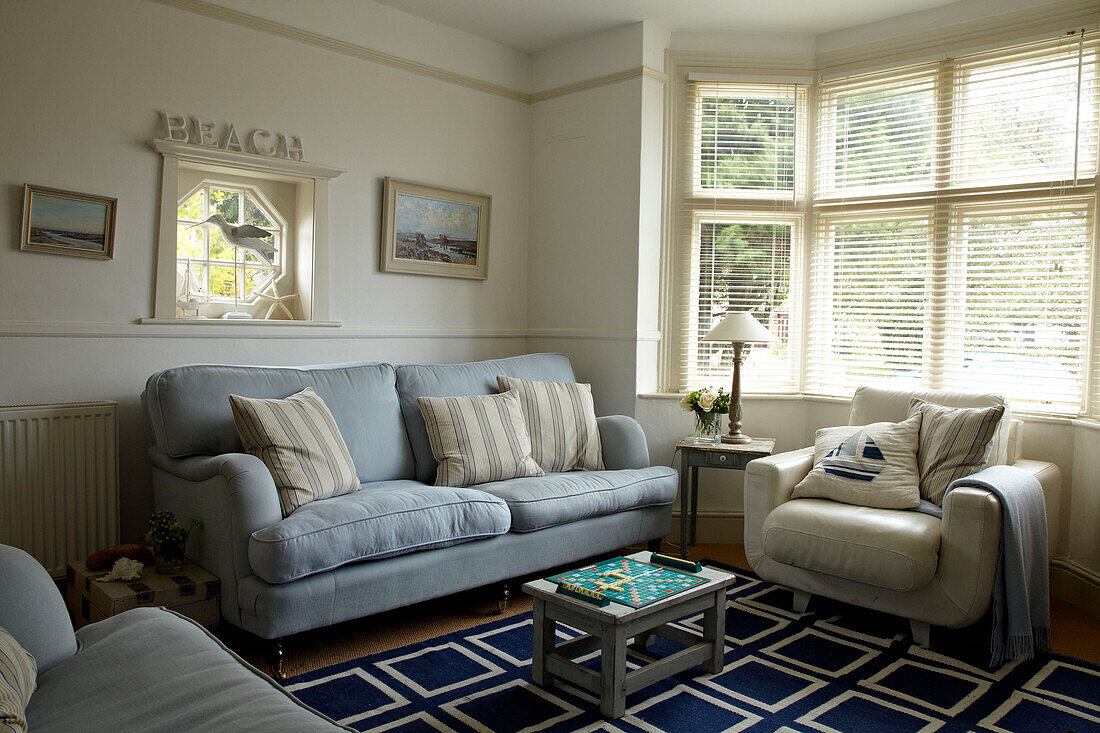 Hellblaues Sofa und cremefarbener Sessel in einem Strandhaus in Norfolk, UK