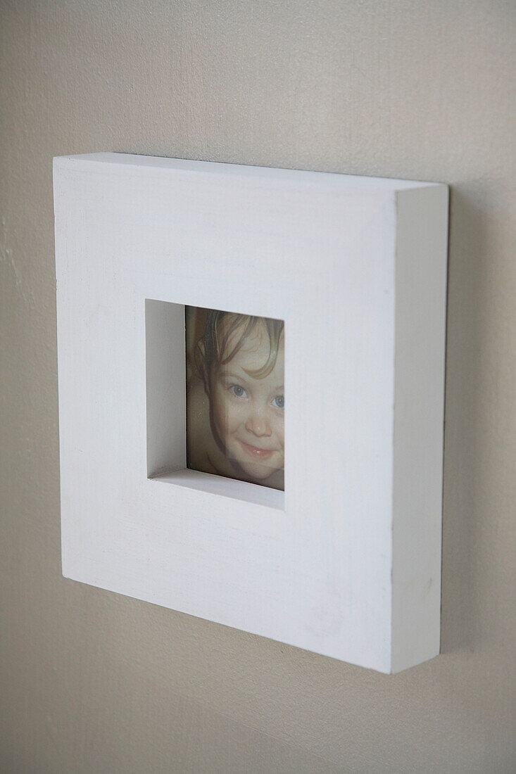 Nahaufnahme eines Fotos mit einem großen weißen Rahmen an der Wand