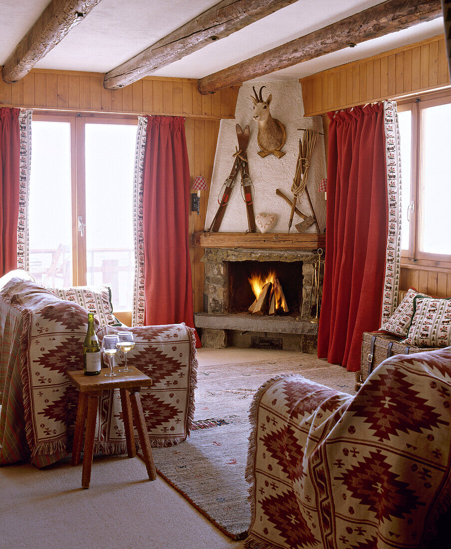 Sitting room with beamed ceiling stone fireplace and sofas with throws