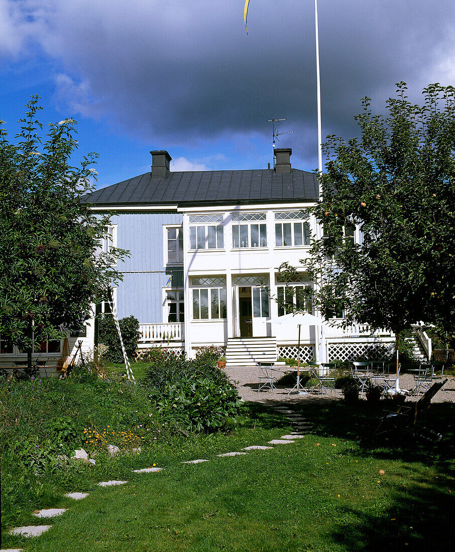 Außenansicht eines blau gestrichenen Holzhauses mit Veranda