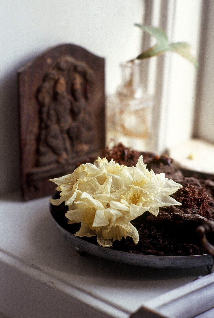 Bowl of dried daffodils and ornaments on window sill