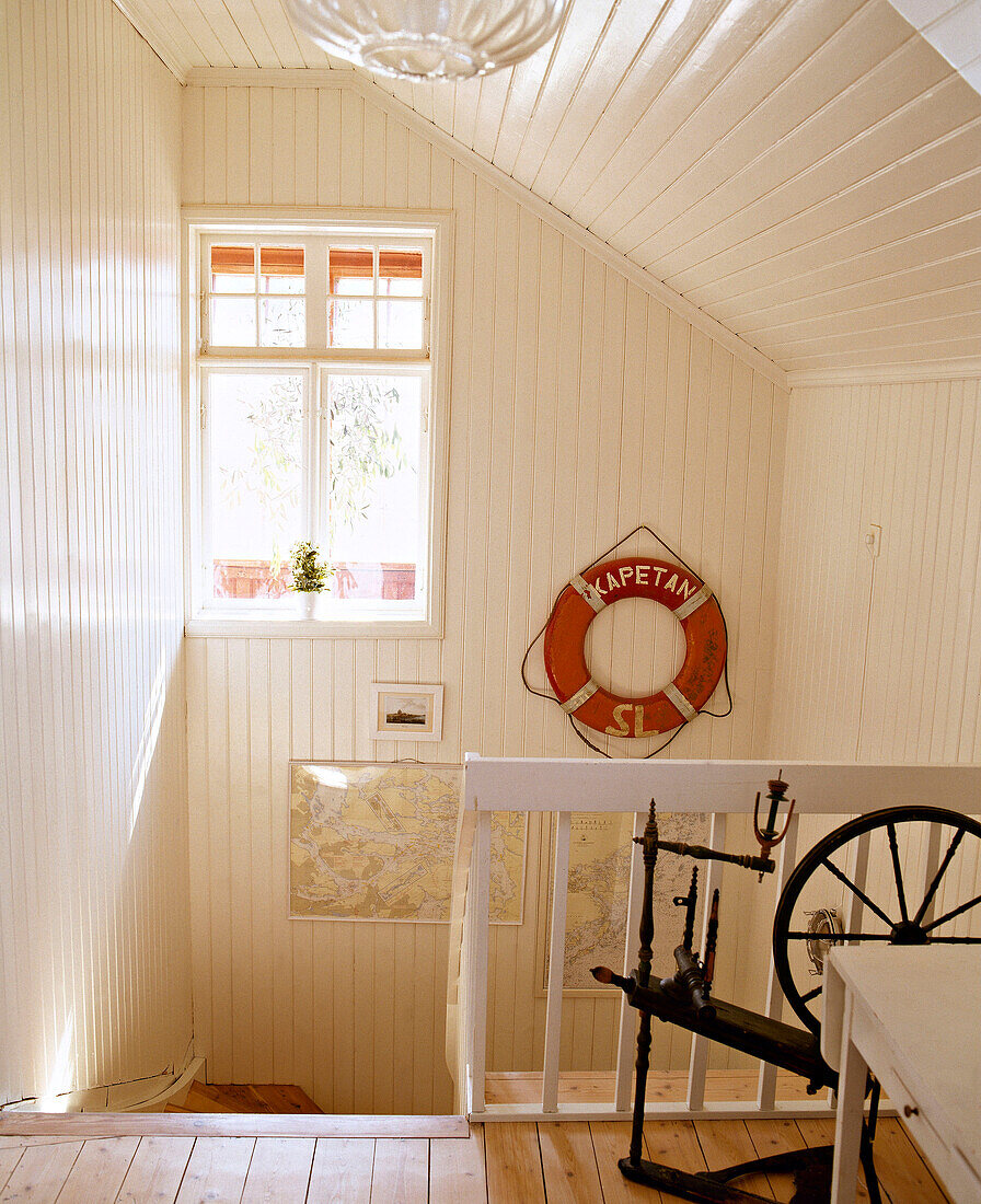 Old fashioned spinning wheel on landing area with timbered walls