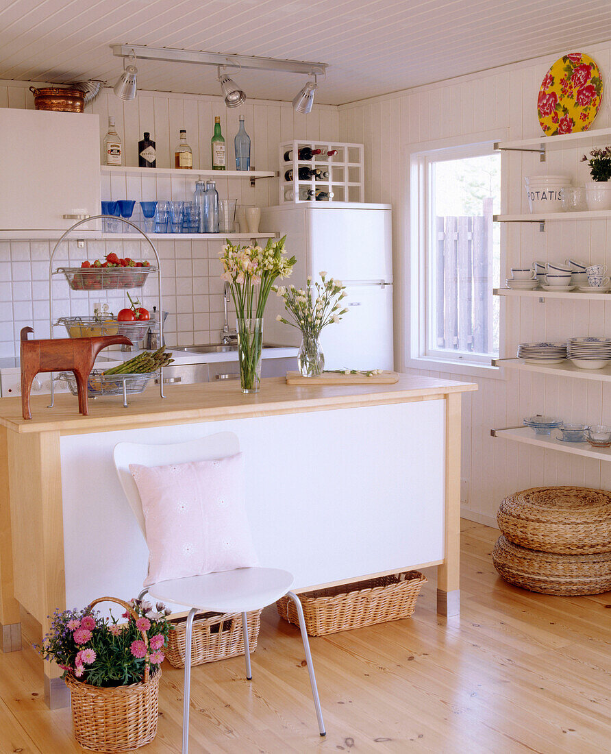 A modern kitchen in neutral colours with central island unit wooden floor