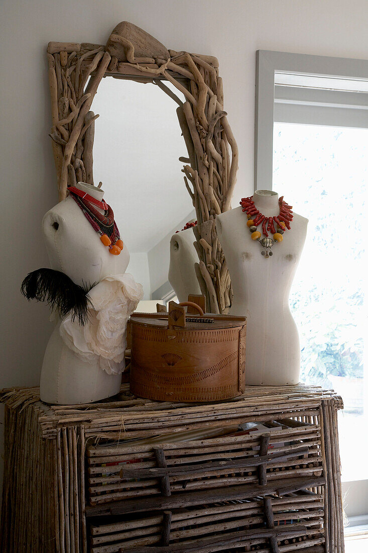 Jewellery on mannequins on top of wooden chest of drawers