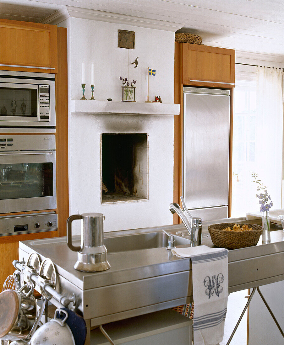 Stainless steel sink unit and integral appliances either side of fireplace