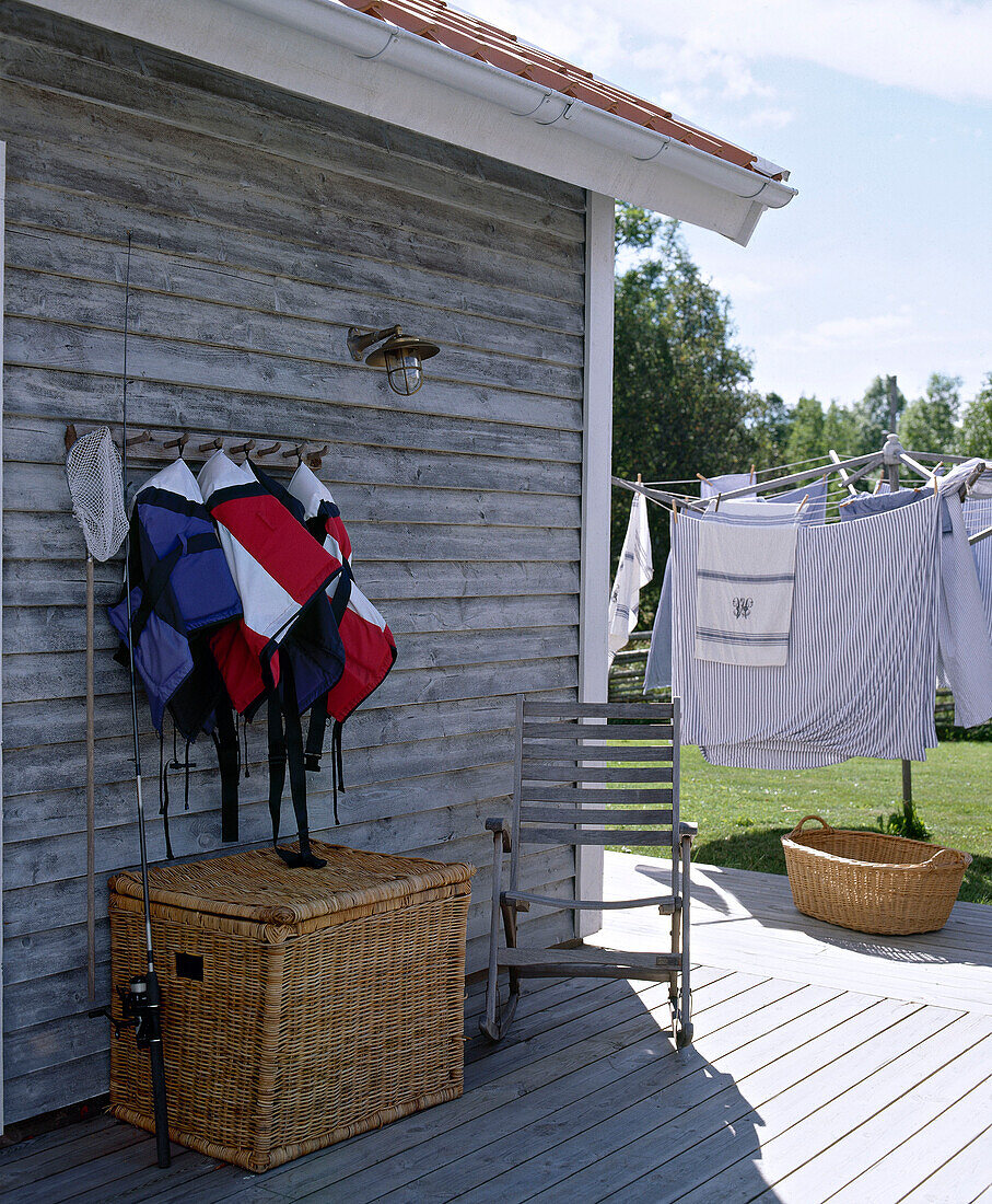 Exterior of timber house with decked area with washing on line in background