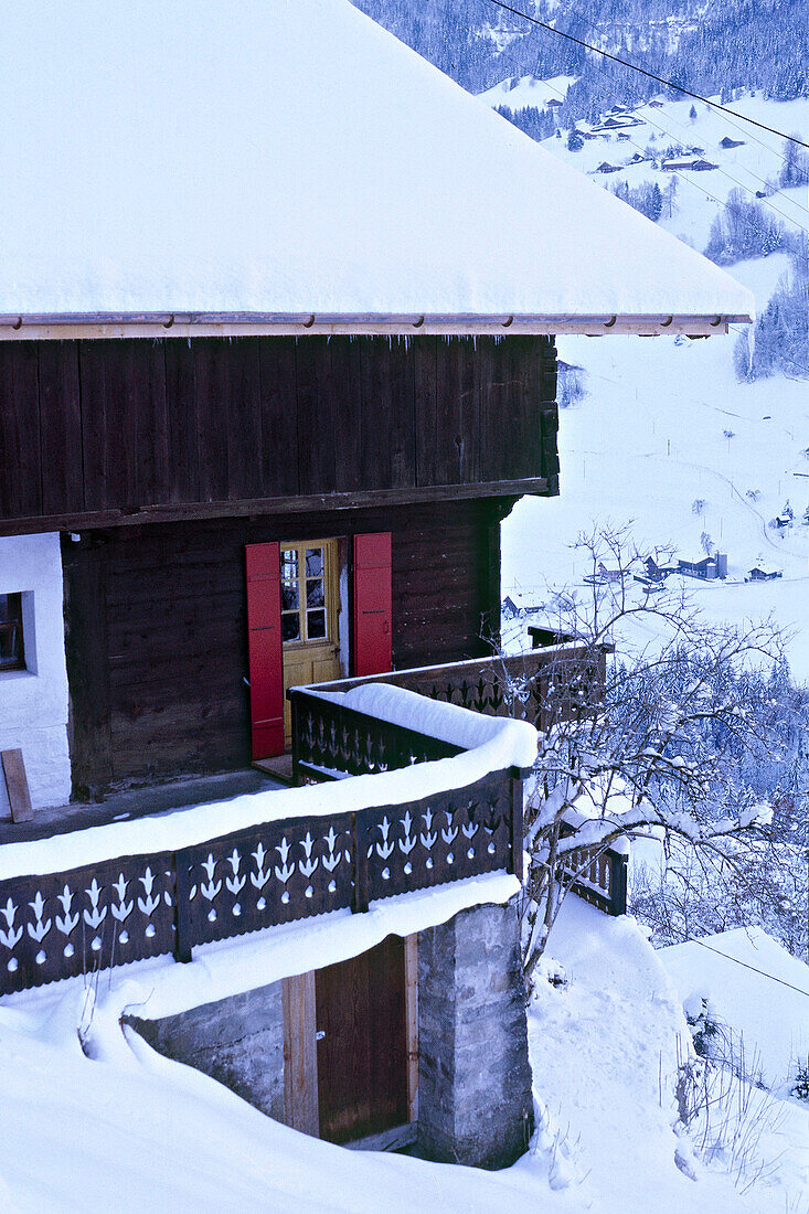 Exterior of snow covered Swiss chalet with balcony