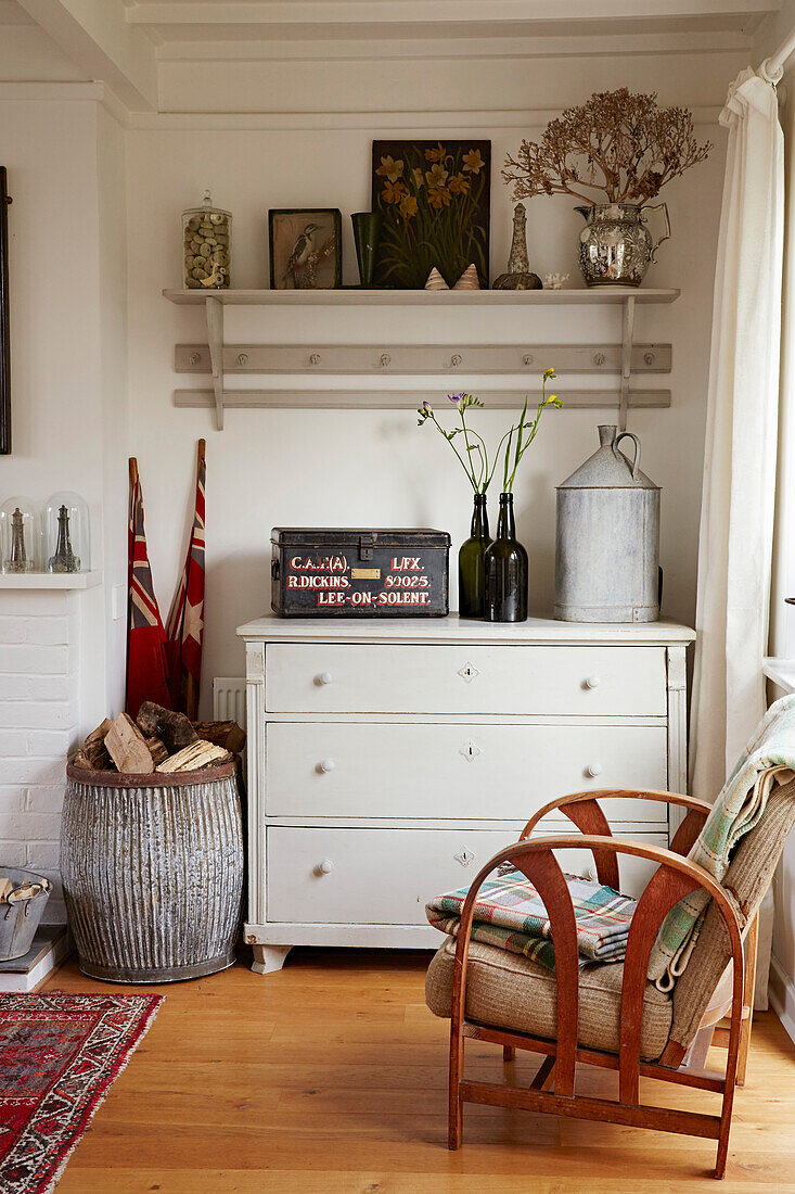 Wooden armchair and chest of drawers with basket of firewood in Shoreham by Sea, West Sussex, UK