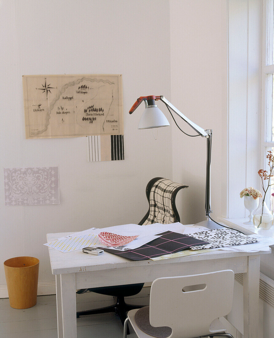 Home office space with a lamp suspended over a white table