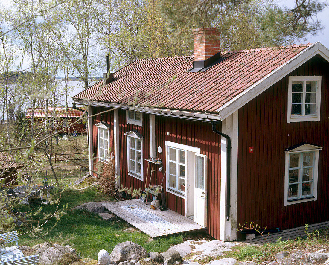 Exterior of a traditional wooden house with a lake in the background