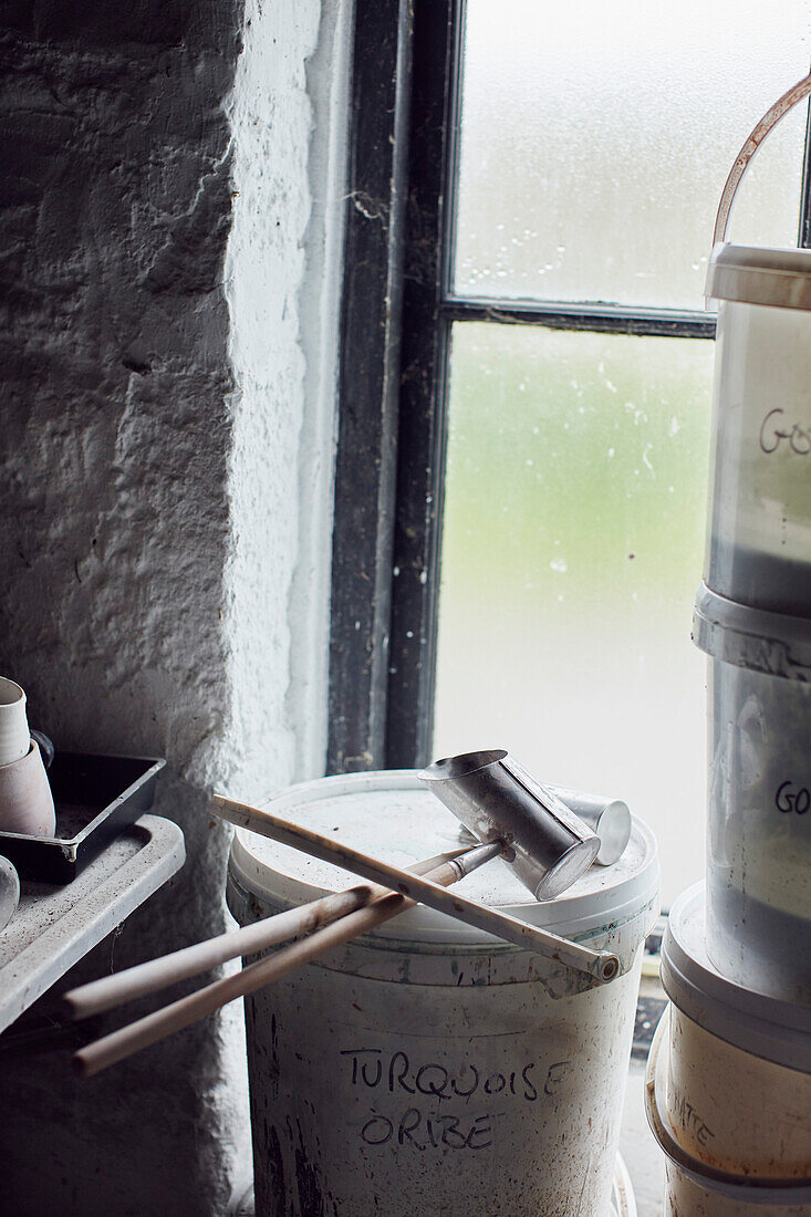 Buckets of ceramic glaze and tools in the Prindl Pottery Cornwall, UK