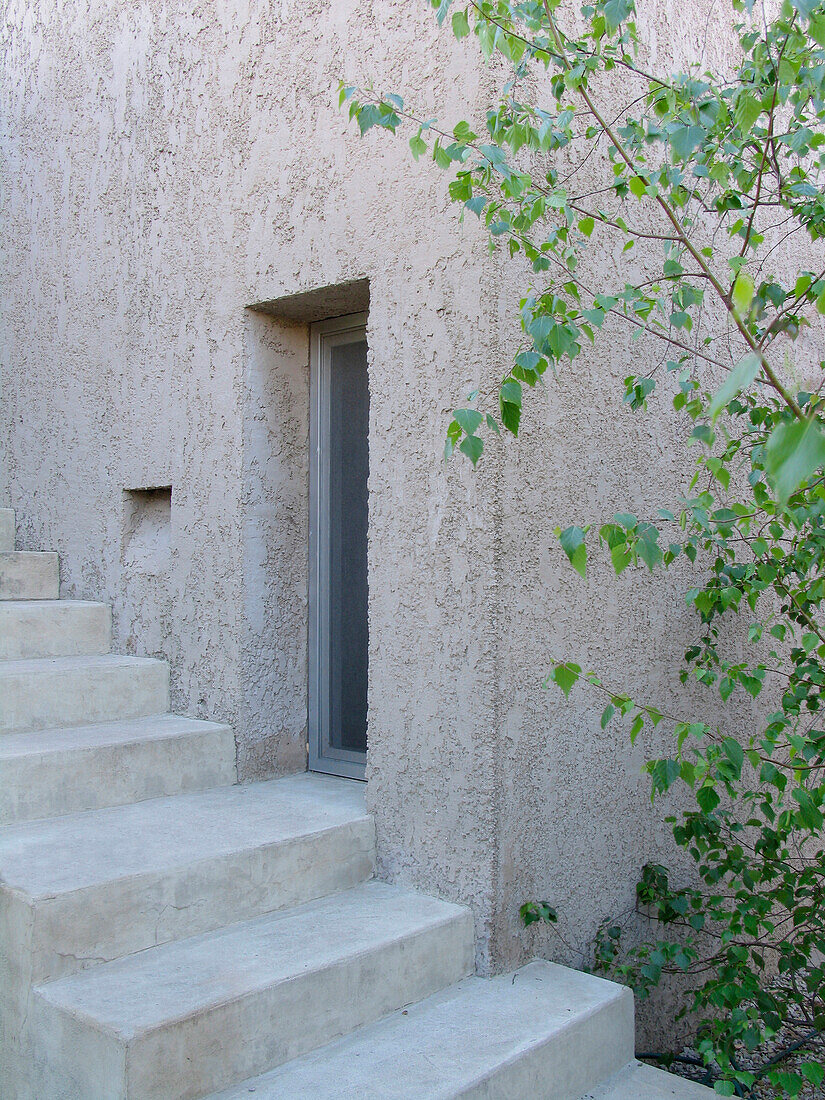 Detail einer Betontreppe an der Seitenfassade eines Hauses