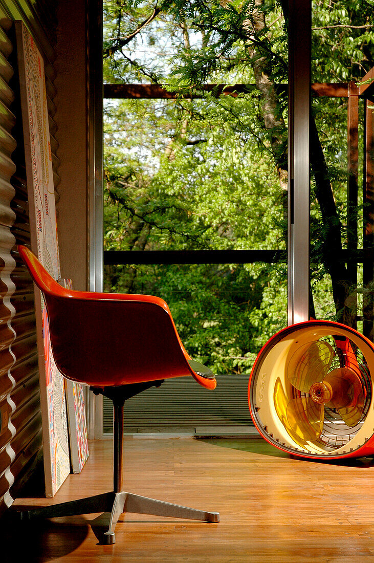 Metal sheeting on walls of entrance hall contrast with a wooden floor